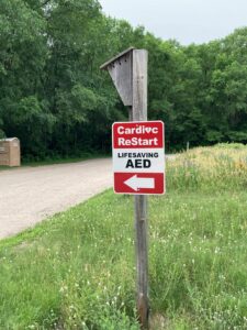 AED sign with arrow on a birdhouse post